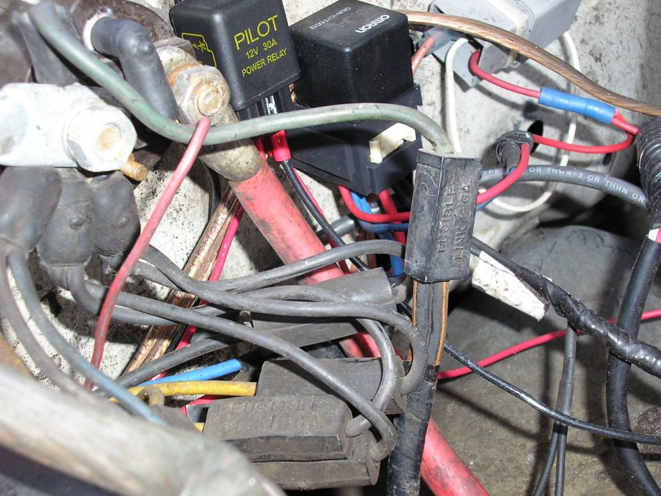 Close-up of tangled automotive wiring with a black PILOT power relay and Omron relay and fusible links.