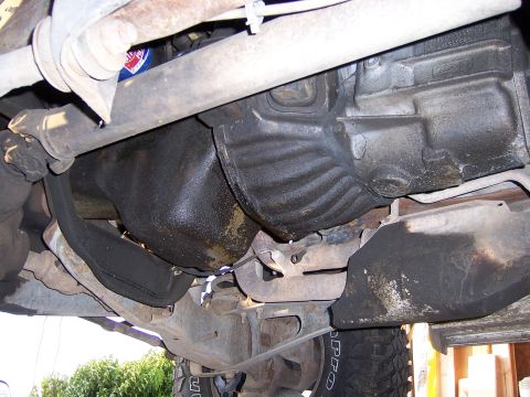 1991 Ford Bronco - Underside view of a vehicle's transmission and oil pan, showing some grease and grime.