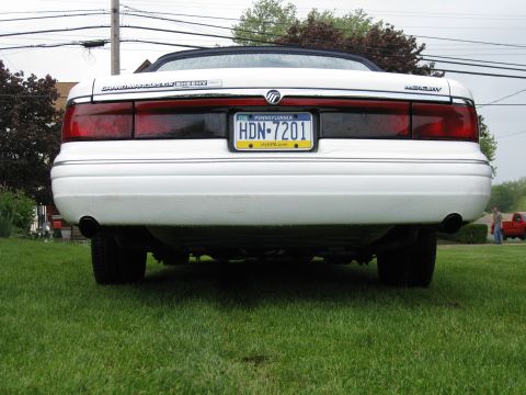 1996 Mercury Grand Marquis - The rear of a white 1996 Mercury Grand Marquis convertible is shown, its distinctive taillights and license plate.