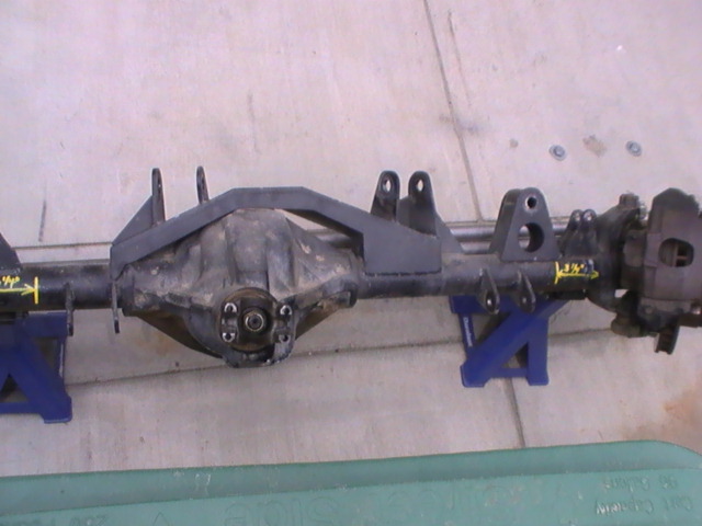 Rear axle assembly on blue jack stands with yellow measurement markings