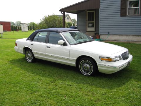 1996 Mercury Grand Marquis - White 1996 Mercury Grand Marquis sedan with a black vinyl top parked on a lawn.