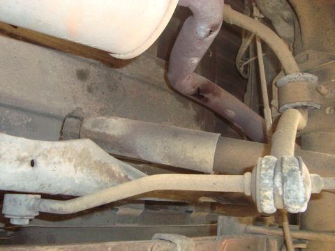 1986 Ford Bronco - Close-up view of the undercarriage, revealing the exhaust system and suspension components.