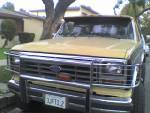 1986 Ford Bronco - This 1986 Ford Bronco features a prominent chrome bull bar and a yellow exterior, seen from the front.
