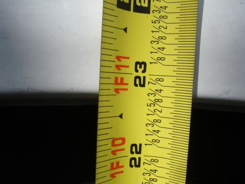 1990 Ford Taurus - A close-up view of a yellow tape measure, displaying measurements in feet and inches, with markings visible up to 23 inches.