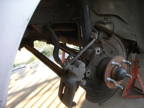 1990 Ford Taurus - Rear suspension assembly with brake components removed, showing the hub and rotor mounting points.