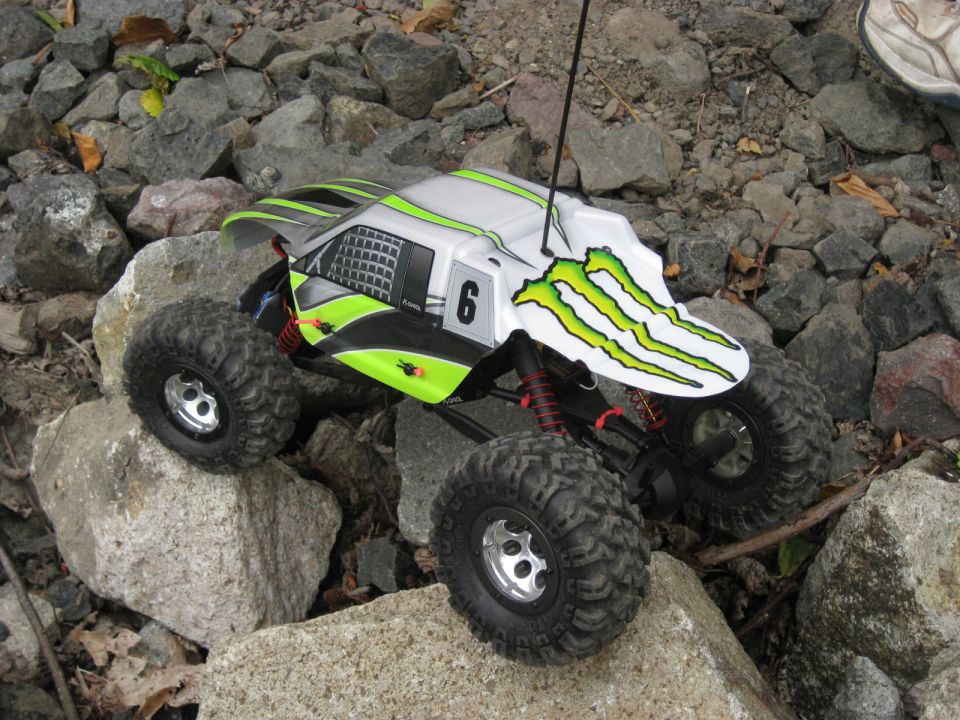 Remote control rock crawler with Monster Energy graphics on a rocky surface