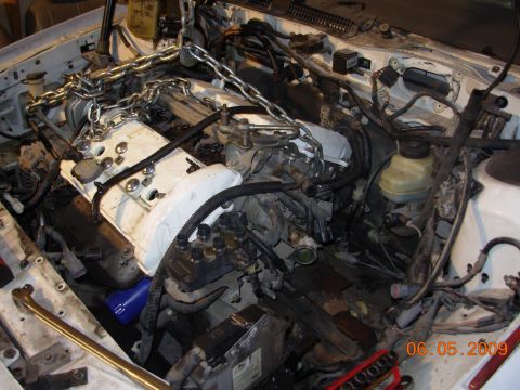 1995 Ford Taurus - The engine bay is shown with a hoist and chains, indicating repair work is in progress.