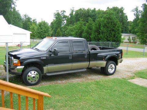 1992 Ford Mustang - This black and tan Ford F-350 pickup truck is parked on a gravel driveway.