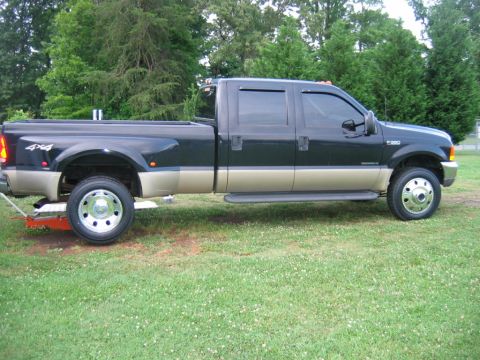 1992 Ford Mustang - A dark green and tan Ford F-350 Super Duty pickup truck is parked on a grassy lawn with trees in the background.
