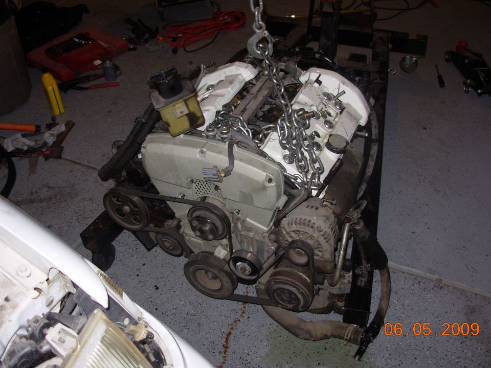 Engine being lifted by chains, white valve covers