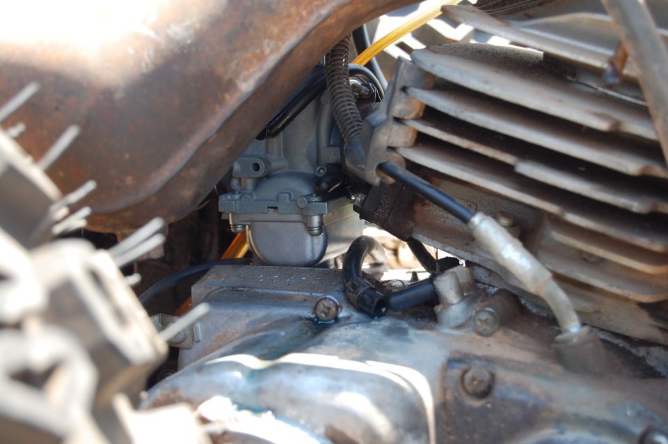Close-up of a motorcycle engine's carburetor and cooling fins