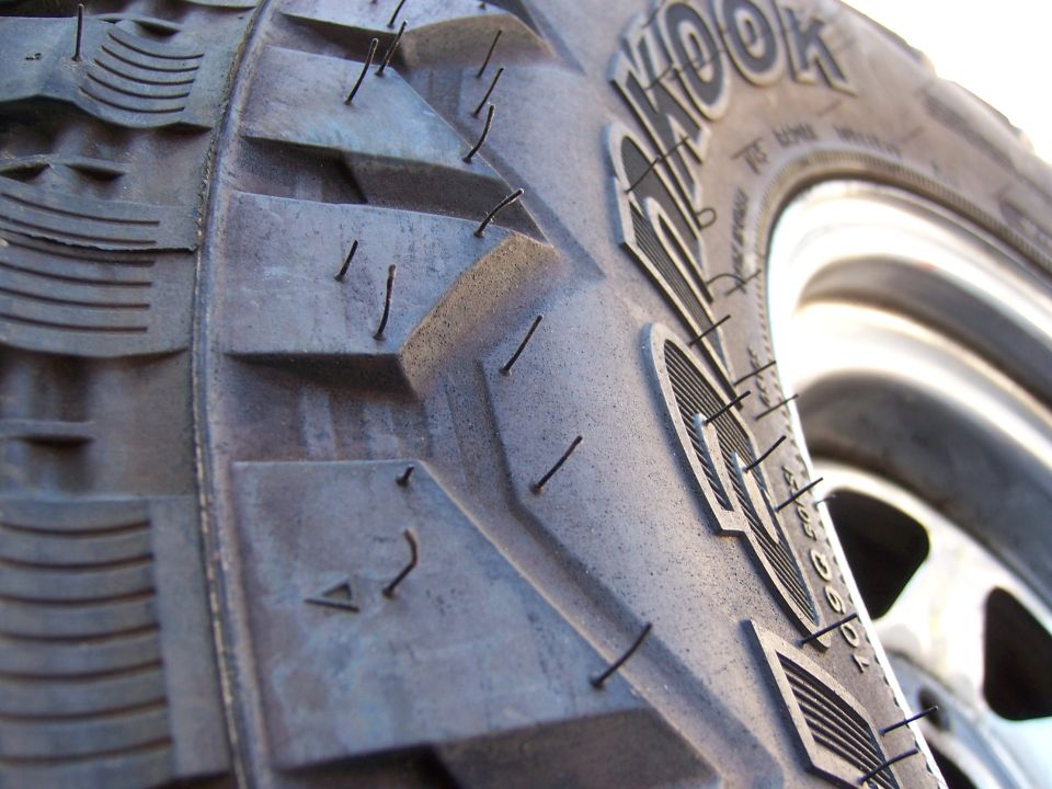 Close-up of a tire tread with embedded wires and visible 'KOOK' branding