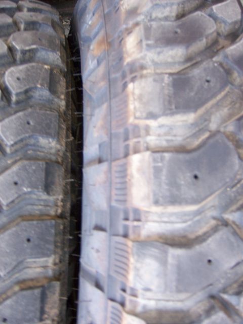 1991 Ford Bronco - Close-up view of two off-road tires, showing their tread patterns.