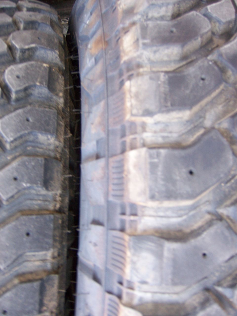 Two off-road tires, one with aggressive tread pattern, side-by-side