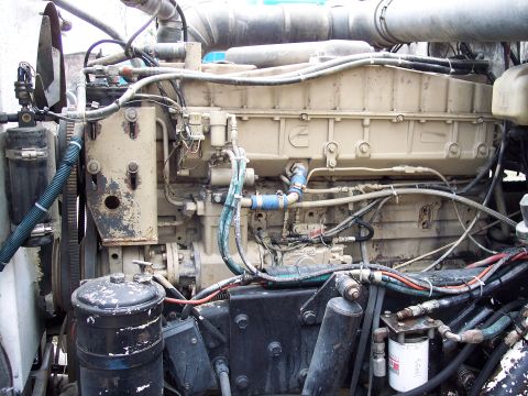 1981 Kenworth W900A - Close-up view of a truck's engine compartment, showing the tan Cummins engine and associated plumbing.