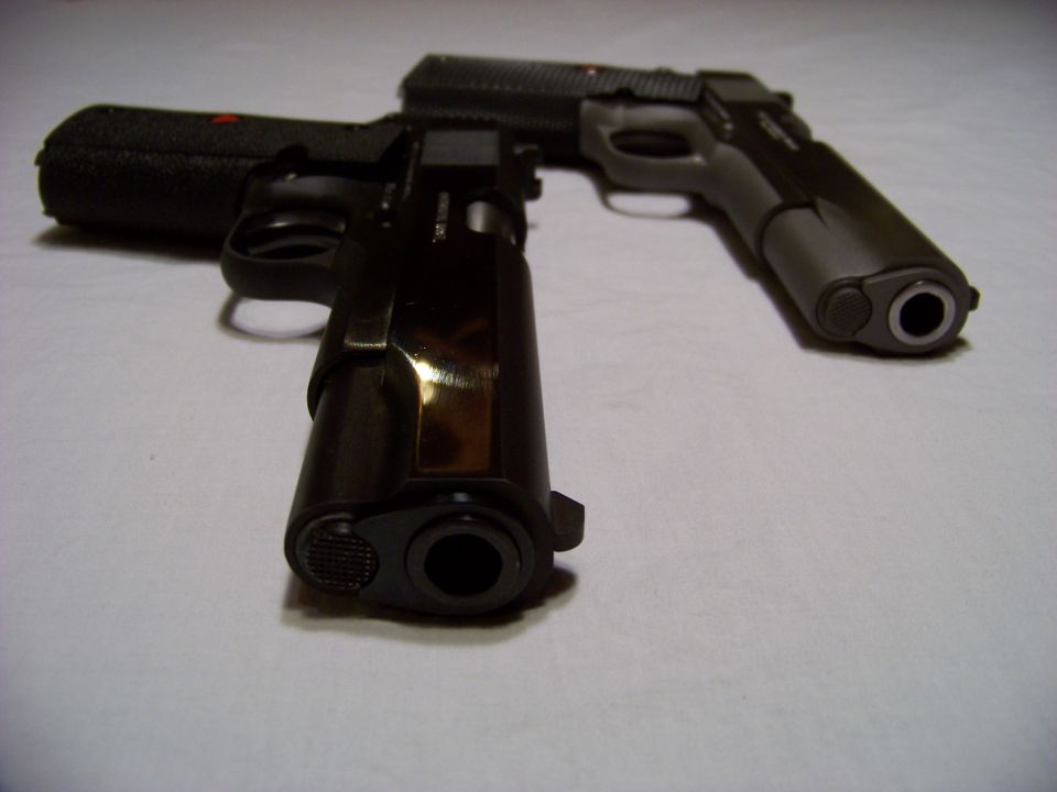 Two handguns on a white surface