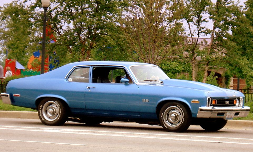 blue 1973 Chevrolet Nova SS coupe with SS badges and a cowl induction hood parked on a street
