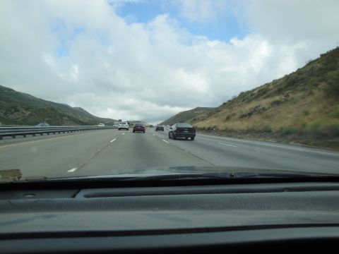 1990 Ford Taurus - View from inside a car driving on a highway with several other vehicles on the road.