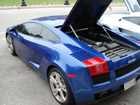 1998 Ford Taurus - A blue Lamborghini Gallardo is shown with its rear engine compartment open, parked on a street.