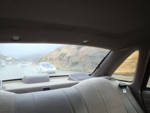 1990 Ford Taurus - Driving on a wet highway with other vehicles, including a 1990 Ford Taurus, in view.