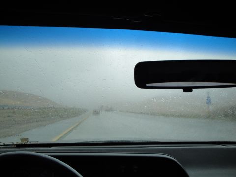 1990 Ford Taurus - Driving through fog and rain on a highway, with other vehicles visible in the distance.