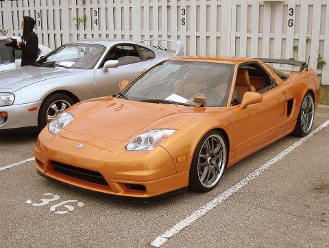 1998 Ford Taurus - An orange sports car is parked in a lot next to a silver vehicle, with parking spot number 36 visible.