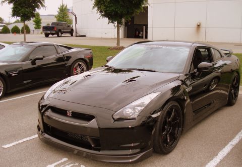 1998 Ford Taurus - Two sports cars, a Nissan GT-R and a Chevrolet Corvette, are parked side-by-side in a lot.