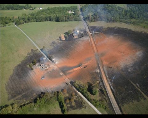1978 Ford Bronco - An aerial perspective captures a large, irregular orange area within a grassy field, possibly indicating a spill or burn.