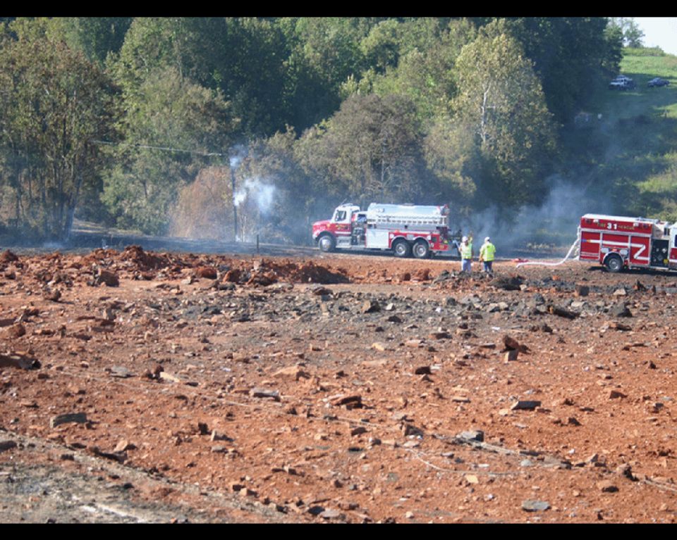 Several off-road vehicles kicking up dust on a dirt track with trees in the background