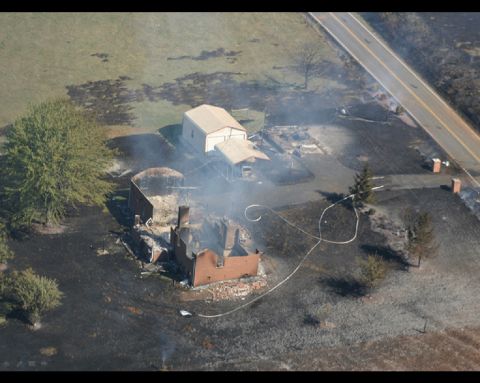 1978 Ford Bronco - An aerial perspective captures a disheveled outdoor area filled with scattered objects and rising smoke.