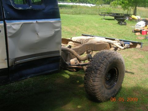 1991 Ford F-150 - Side view of a 1991 Ford F-150 with a heavily damaged door and exposed chassis.