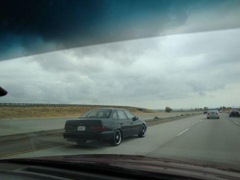 1990 Ford Taurus - Black 1990 Ford Taurus seen from another vehicle on the highway.