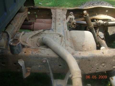 1991 Ford F-150 - Close-up view of the undercarriage of a truck, showing frame and suspension components, with dual exhaust pipes.