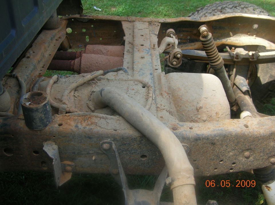 Truck frame and suspension with dual exhaust pipes visible