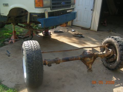 1991 Ford F-150 - The front axle assembly of a 1991 Ford F-150 is shown removed from the vehicle, which is supported by jack stands.