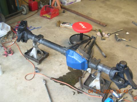1991 Ford F-150 - A Dana 60 axle assembly is shown disassembled and supported by jack stands in a garage setting.