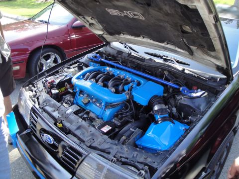 1990 Ford Taurus - Engine bay of a 1990 Ford Taurus SHO, a custom blue intake system and strut bar.