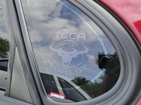 1990 Ford Taurus - A close-up of a car's rear window displays various stickers, including one for TCCA Midwest.