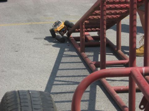 1987 Suzuki Samurai - A yellow remote control rock crawler toy is positioned on a red metal ramp.