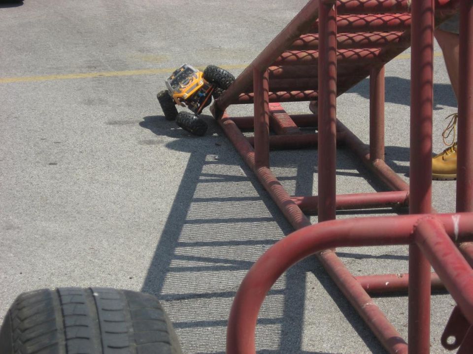Yellow remote control rock crawler toy on a red metal ramp