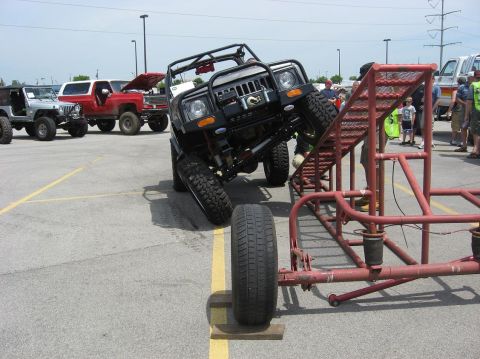 1987 Suzuki Samurai - An off-road vehicle navigates a challenging obstacle course, demonstrating its suspension capabilities.