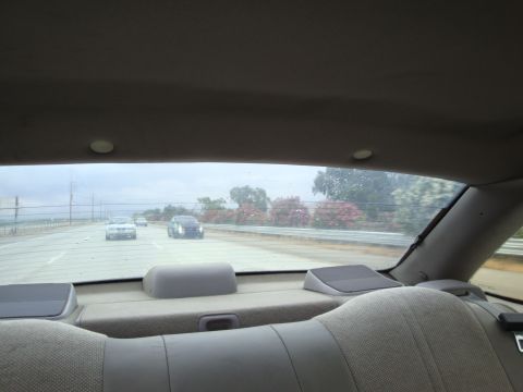 1990 Ford Taurus - Driving on the highway with other vehicles on a cloudy day.
