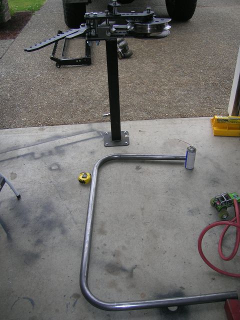 1996 Ford Bronco - A tube bender and a piece of bent metal tubing are laid out on a concrete surface, possibly for a custom vehicle modification.