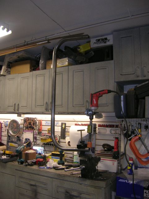1996 Ford Bronco - Workbench setup with a metal pipe bending tool and various tools stored in cabinets.