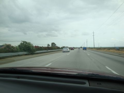 1990 Ford Taurus - A view from inside a vehicle driving on a highway with other cars on the road.