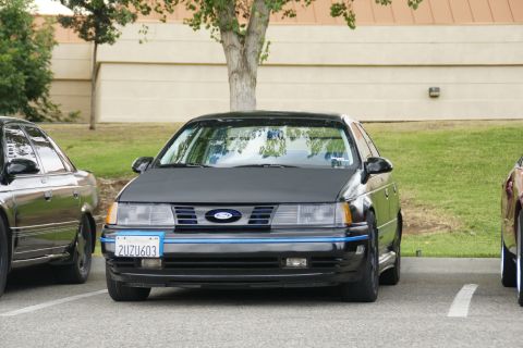 1990 Ford Taurus - This 1990 Ford Taurus features a distinctive blue stripe across its front grille and bumper.