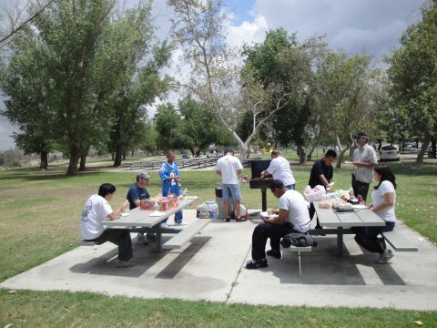1990 Ford Taurus - A group of people enjoy a picnic lunch in a park on a cloudy day.