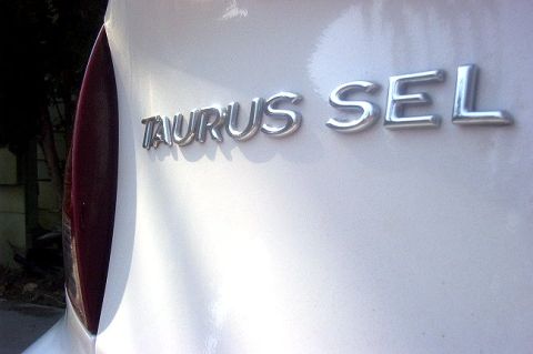2000 Ford Taurus - The rear emblem clearly reads 'TAURUS SEL' on a white vehicle.