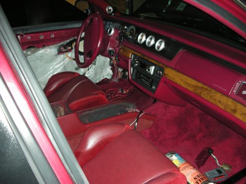 1992 Ford Crown Victoria - The interior of a 1992 Ford Crown Victoria shows red upholstery, aftermarket gauges, and exposed wiring.