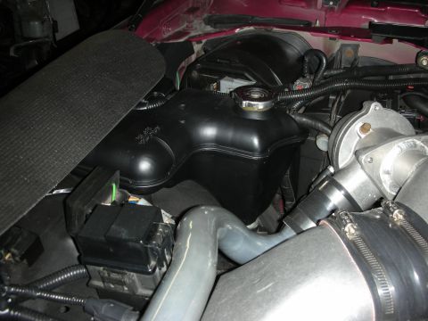 1992 Ford Crown Victoria - This image shows a close-up view of a vehicle's engine bay, focusing on the coolant reservoir and associated plumbing.
